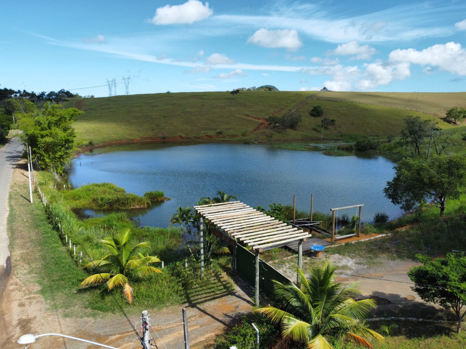 Vista da lagoa com deck, vegetação e montanhas ao fundo
